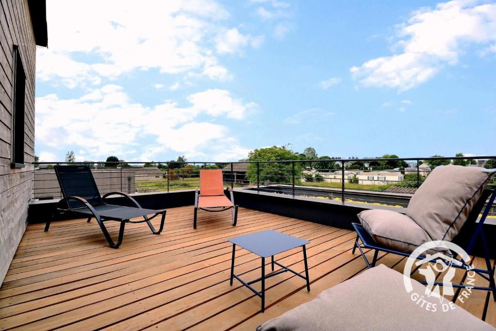 a deck with chairs and a couch on a balcony at Entre terre et mer in Cherrueix