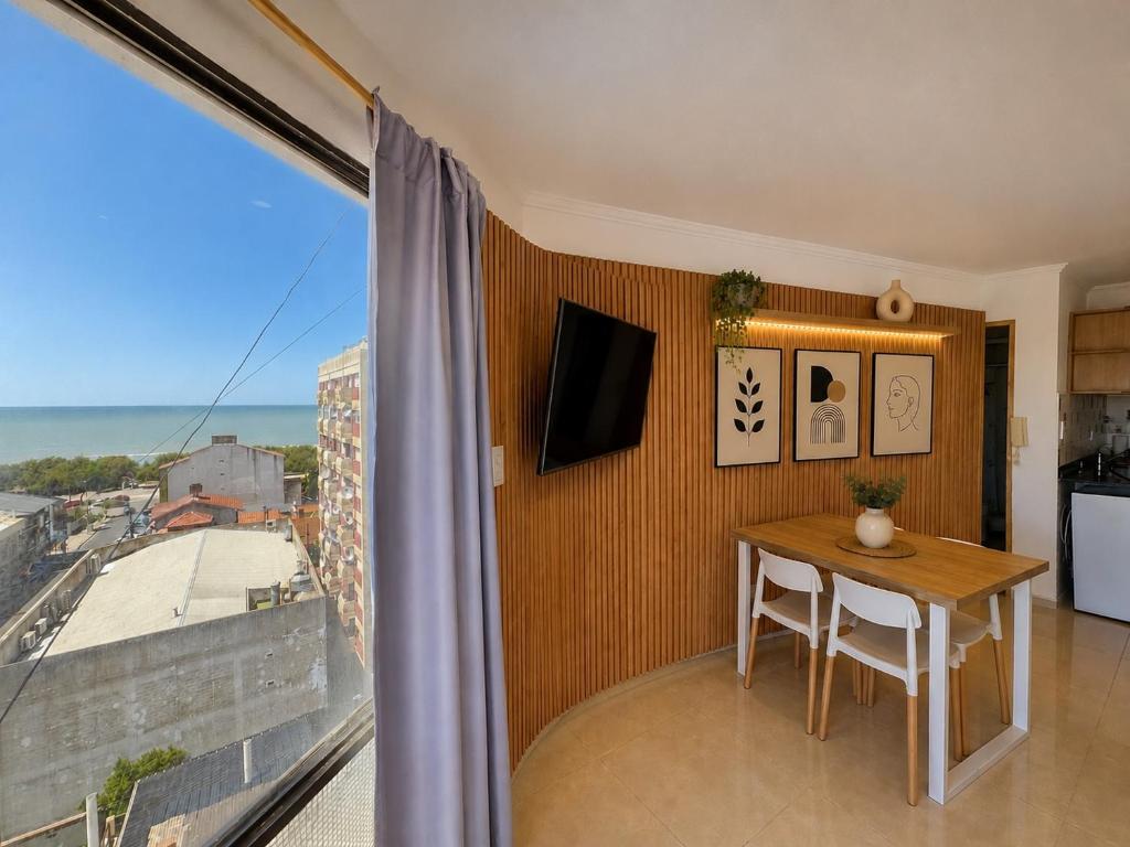 a dining room with a table and a large window at Suite Premium Vista Panorámica in Santa Teresita