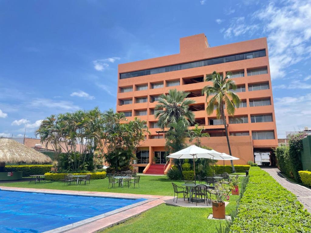 a resort with a swimming pool and a building at Hotel de Cuautla in Cuautla Morelos