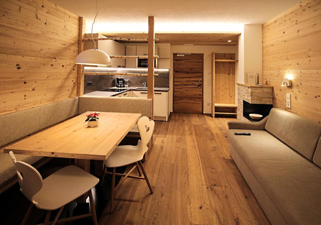 ein Wohnzimmer mit einem Holztisch und einem Sofa in der Unterkunft Appartement Hotel Erlhof Deluxe in Luttach
