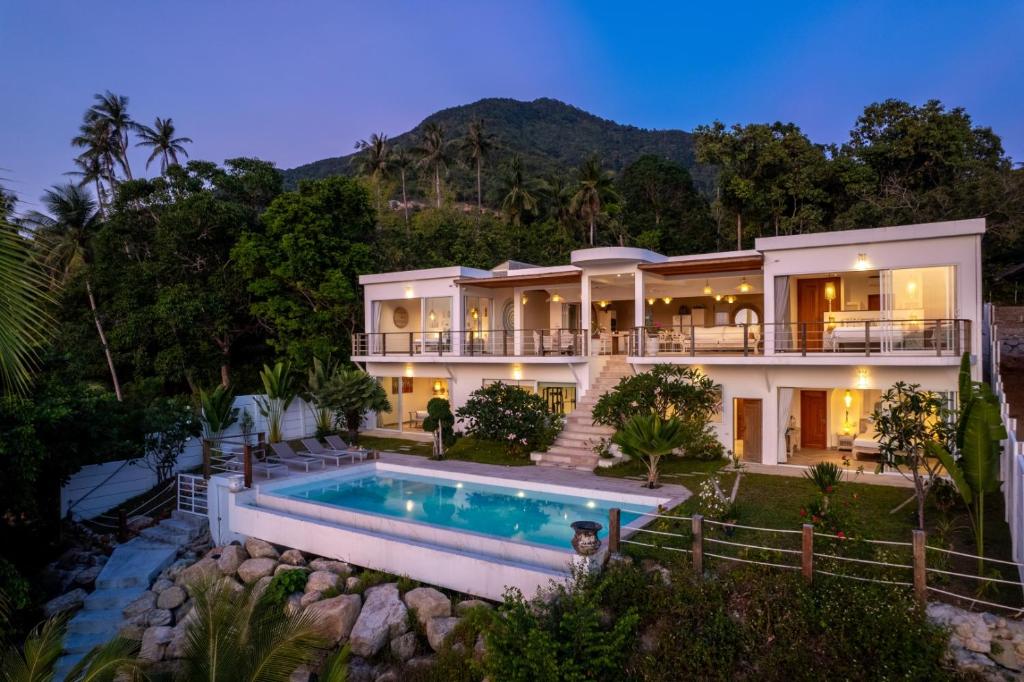 a large house with a swimming pool in front of it at Hortensia Luxury Beach Villa in Chaloklum