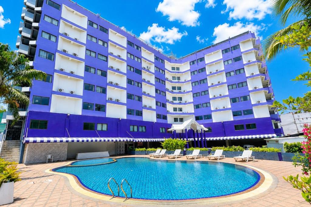 a hotel with a swimming pool in front of a building at Sawasdee Siam Pattaya Hotel in Pattaya
