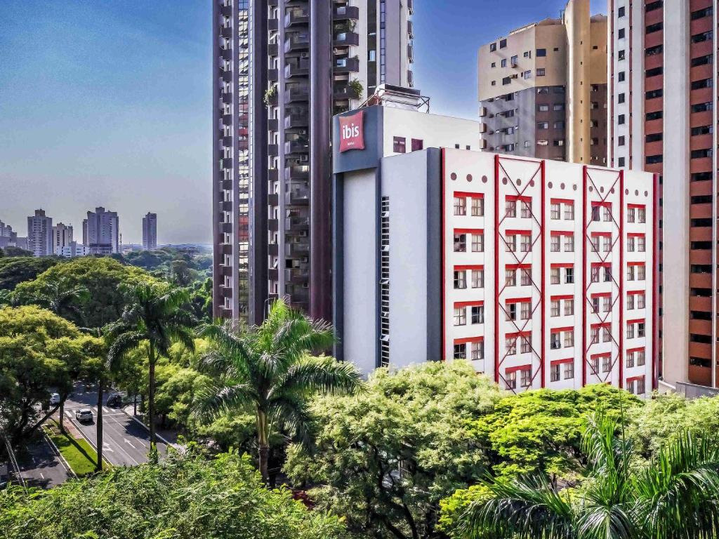 a tall white building in the middle of a city at Ibis Maringa in Maringá