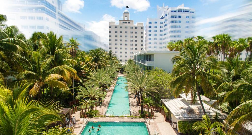 uma vista sobre uma piscina com palmeiras e edifícios em National Hotel, An Adult Only Oceanfront Resort em Miami Beach
