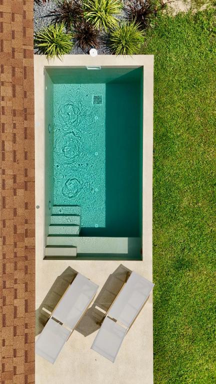 two white chairs sitting in front of a green wall at Samma Villas - Onyx Villa - 1 BDR & Private Pool in Ko Phangan