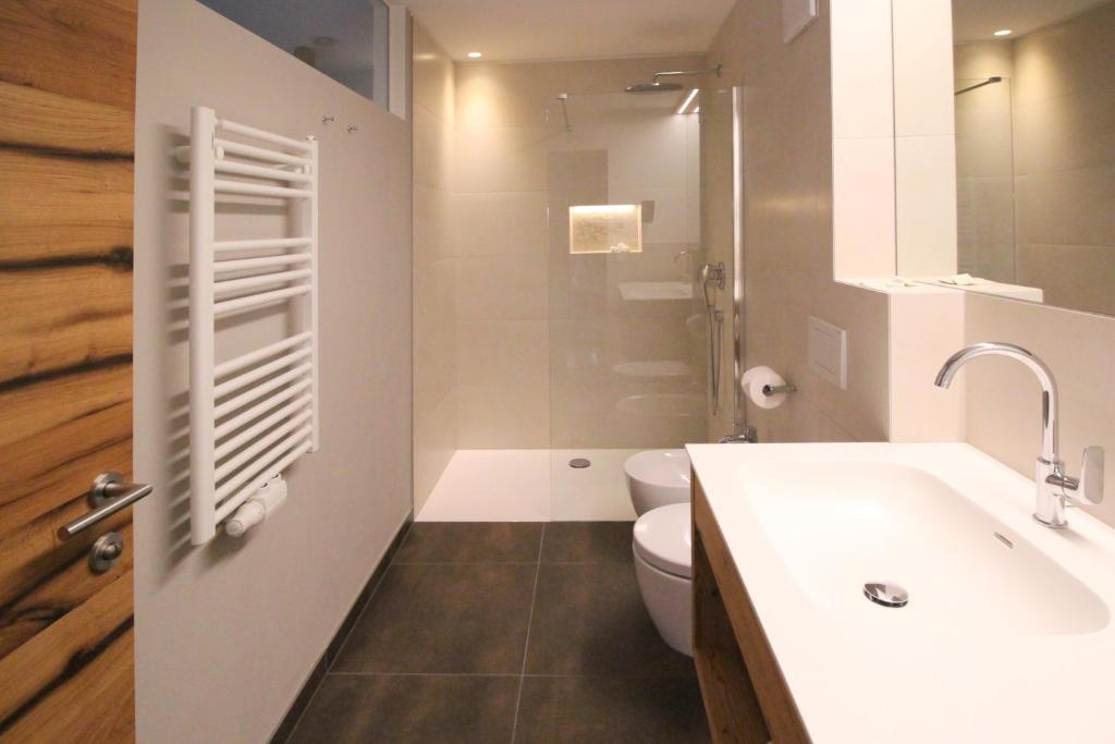 a bathroom with a sink and a toilet at Appartement Hotel Erlhof Deluxe in Lutago