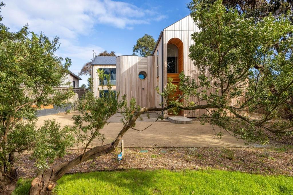 ein Holzhaus mit einem Baum im Garten in der Unterkunft Axbridge in Flinders