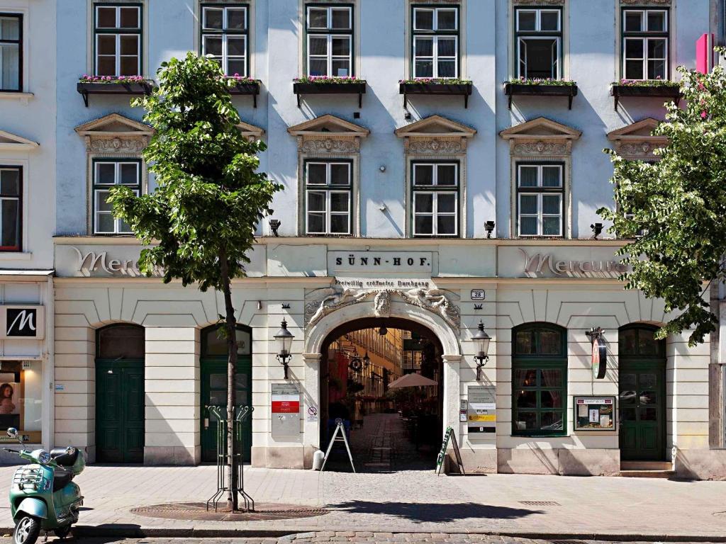 a blue building with an archway in front of it at Mercure Grand Hotel Biedermeier Wien in Vienna