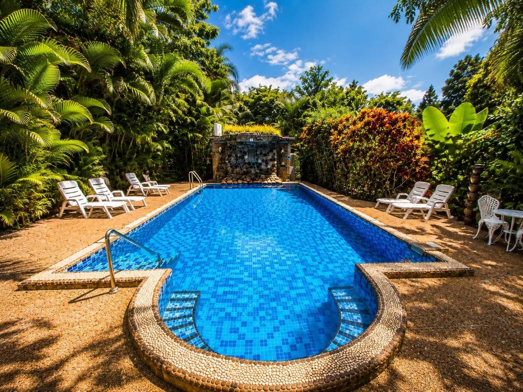 a large swimming pool with chairs and a swimming pool at Hotel Khaosok and Spa in Khao Sok National Park