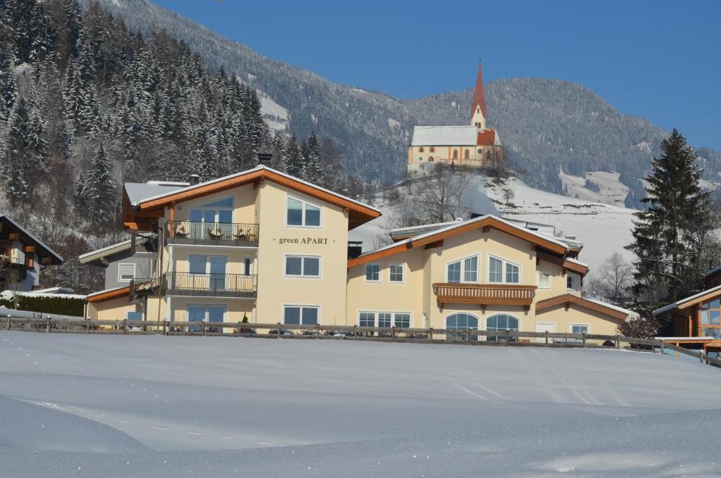 un grand bâtiment avec une patinoire devant dans l'établissement Green Apart, à Uderns