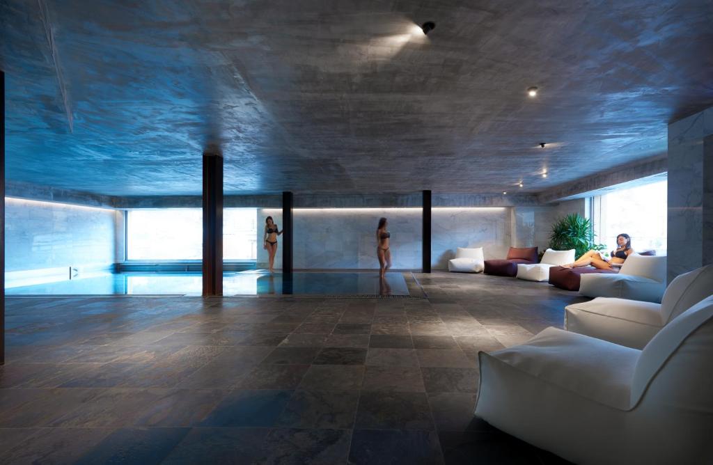 a living room with a couch and people in it at Aux Pieds du Roi - Suite & Spa in Breuil-Cervinia
