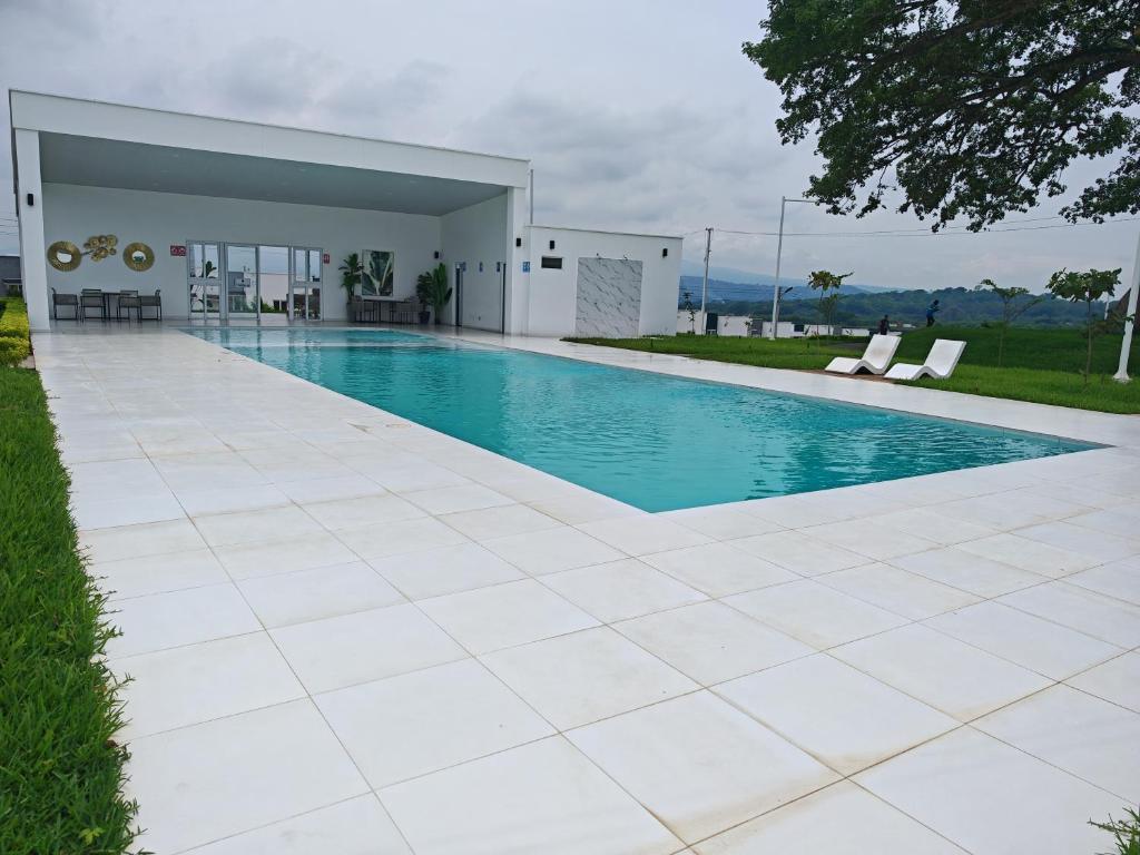 a swimming pool in front of a house at Hermosa casa con piscina in Sitio del Niño