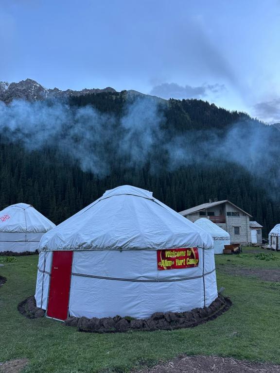 a large white tent in a field with a mountain at Alim yurt camp in Mineralʼnyy Istochnik Altyn-Arasan