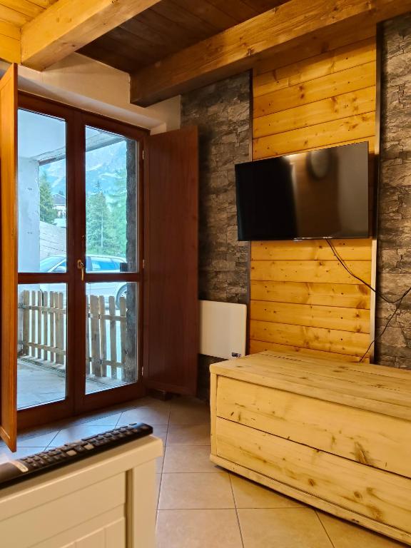 a living room with a large window and a flat screen tv at Casa Meli in Passo del Tonale