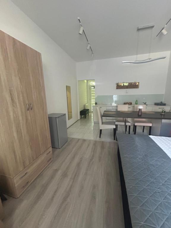 a white room with a bed and a dining room at Freedom apartman in Zamárdi