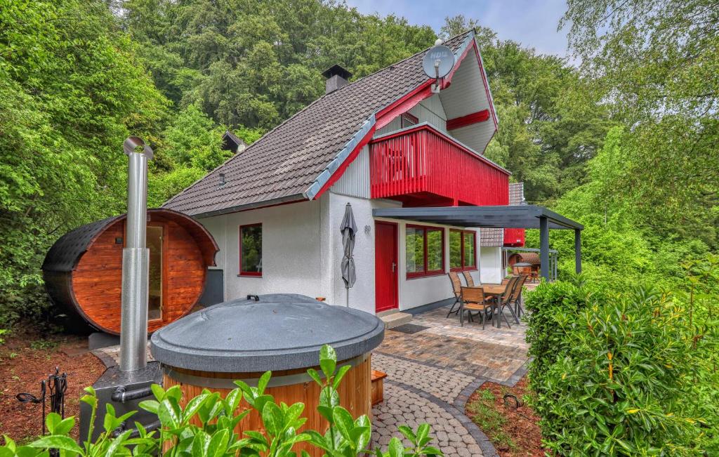 a small red and white house with a large barrel next to it at Maier Kirchheim in Kemmerode