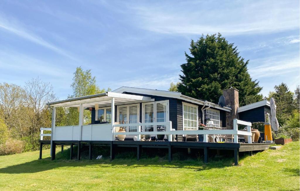 a house with a large deck on the grass at Gorgeous Home In Hundested With Wifi in Hundested