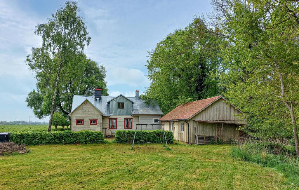an old house and a barn in a field at Paulinas Hus in Laholm