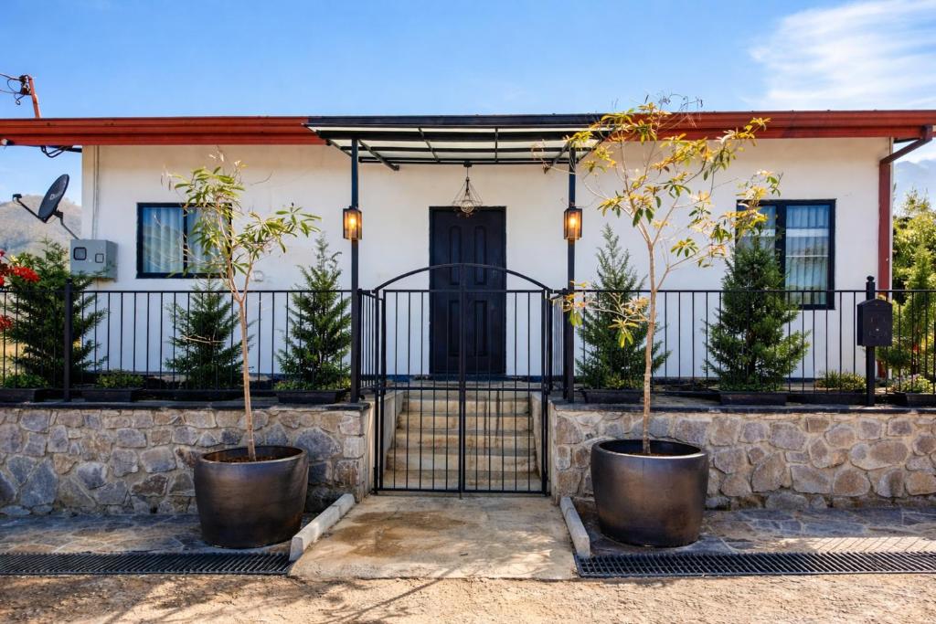 a house with a fence and two potted trees at 007Dickoya in Dikoya