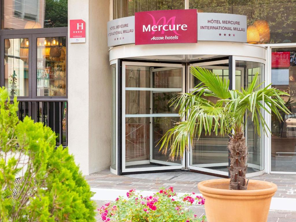 a store front with a potted plant in front of it at Mercure Millau in Millau