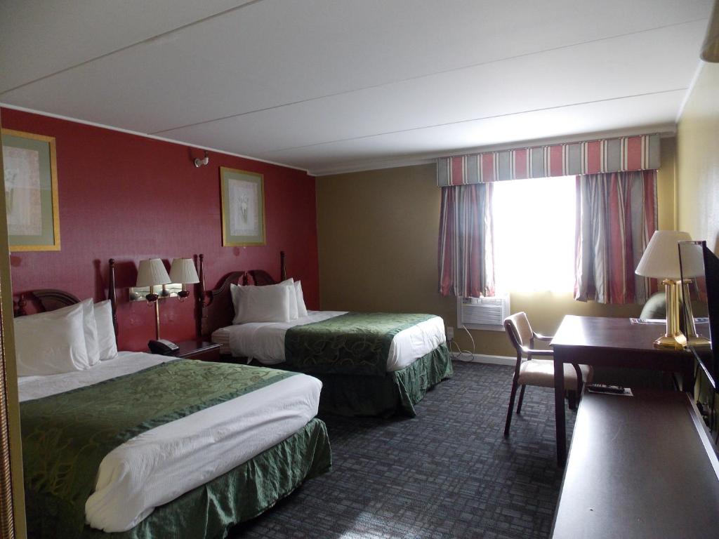 Habitación de hotel con 2 camas y escritorio en Center Street Value Inn, en Auburn
