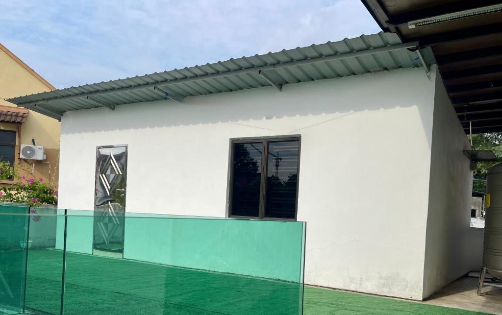 a white house with a glass fence in front of it at Balcony Garden Studio in Johor Bahru