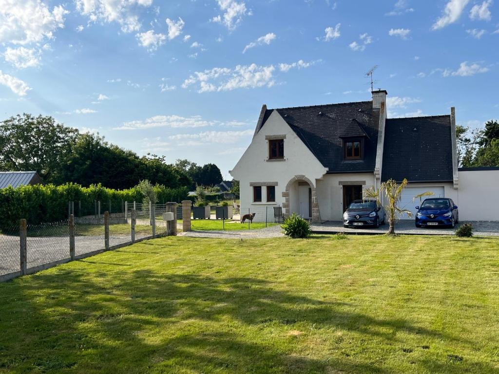 a white house with a fence and a yard at Maison proche dinan au calme in Aucaleuc