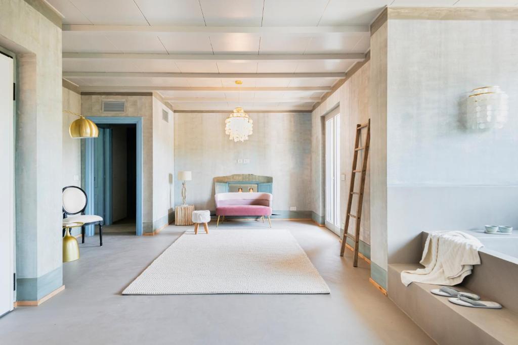 a room with a pink bed and a pink chair at L'Attico di Asilo in Barolo in Barolo