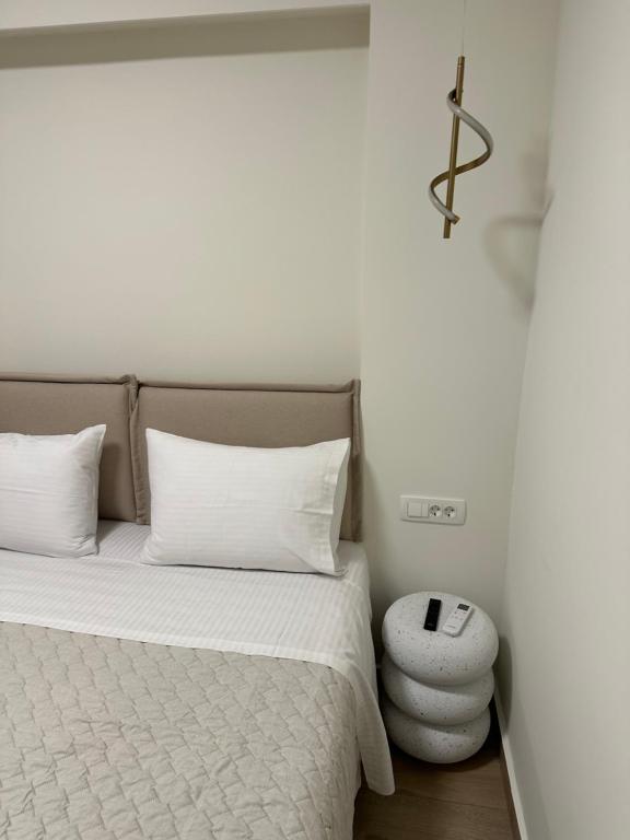 a bedroom with a bed with white sheets and a stool at K&L Luxury Suite 2 in Parga