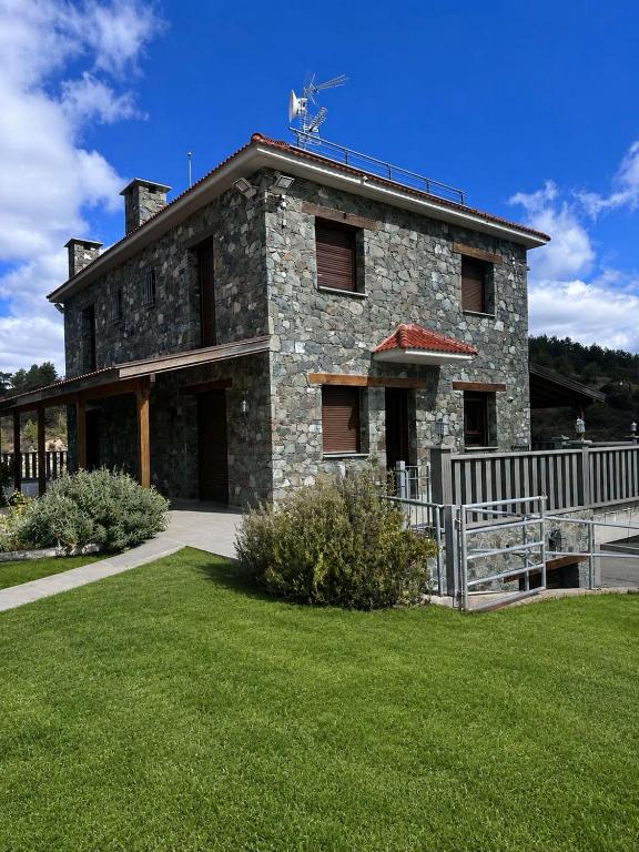 a stone house with a fence in front of it at Kyperounta Heights - Breathtaking View in Kyperounda