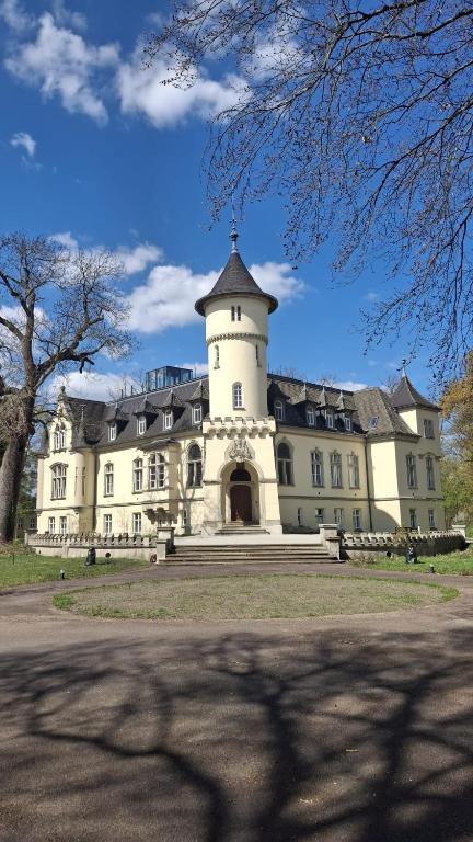 a large white building with a tower on top of it at Schlosshotel Hohenbocka in Hohenbocka