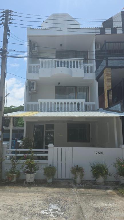 a white building with potted plants in front of it at Chillax Townhome 65 in Hua Hin