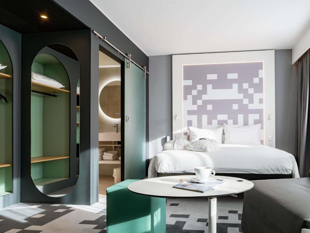 a bedroom with a bed and a coffee table at ibis Styles Béziers Centre in Béziers