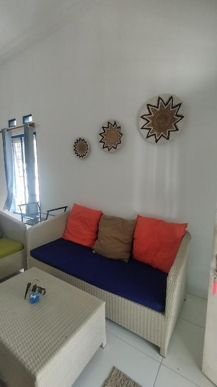 a living room with a couch with colorful pillows at Rumah Senden Guesthouse in Yogyakarta