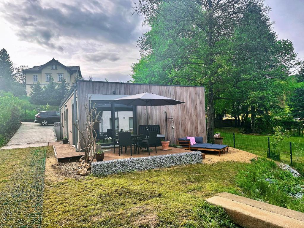 a small house with a patio and an umbrella at Schmidtsches Quartier in Oybin