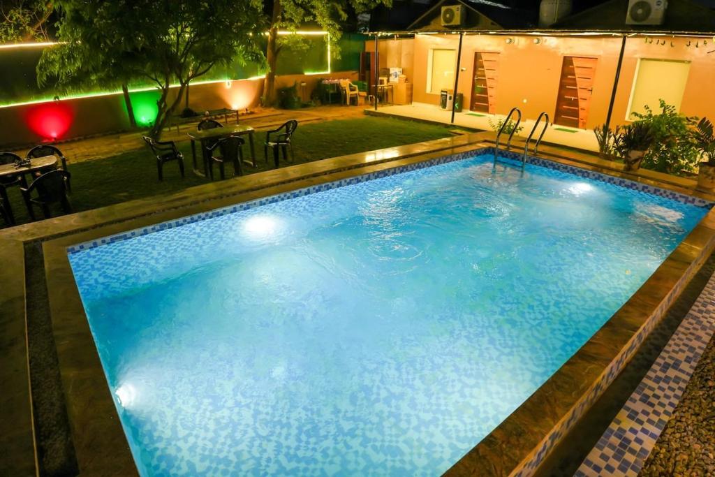 a large pool with blue water at night at Saanjh Private Pool Villa Jaipur in Jaipur