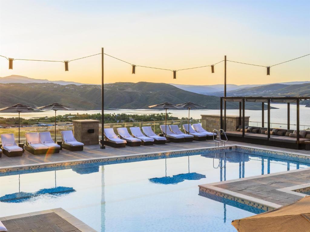 a swimming pool with lounge chairs and umbrellas at Grand Hyatt Deer Valley in Park City