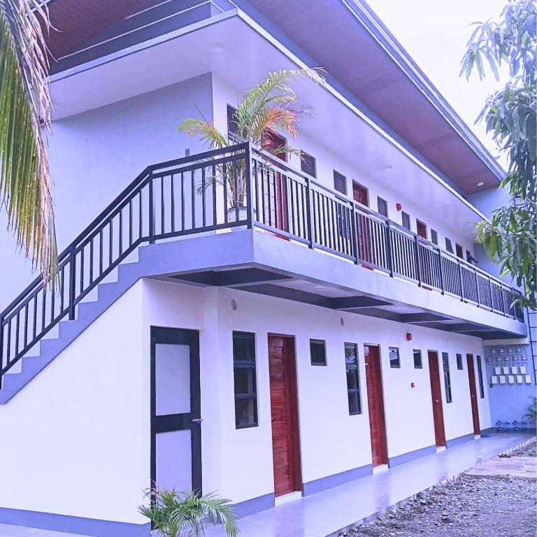a white house with a staircase on it at MartiVille Residences in Gloria
