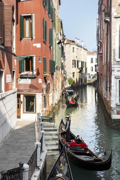 a gondola is parked next to a canal with buildings at Hotel Riva in Venice