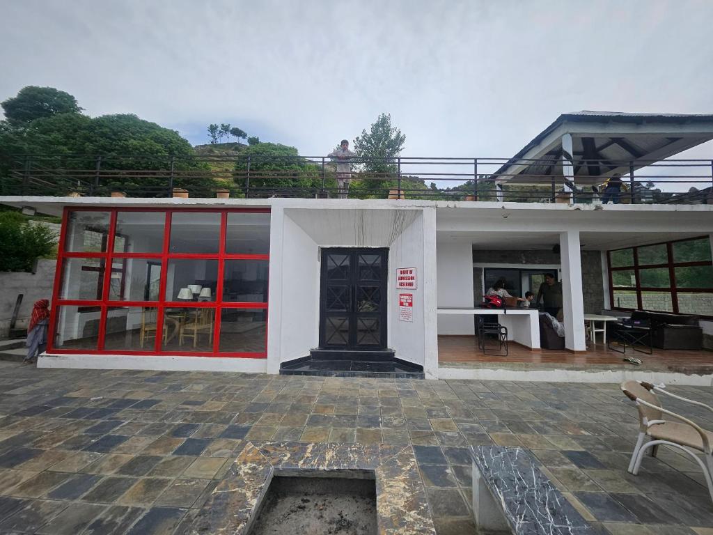 a white building with red doors and a patio at The Terraces by 12th Avenue in Murree