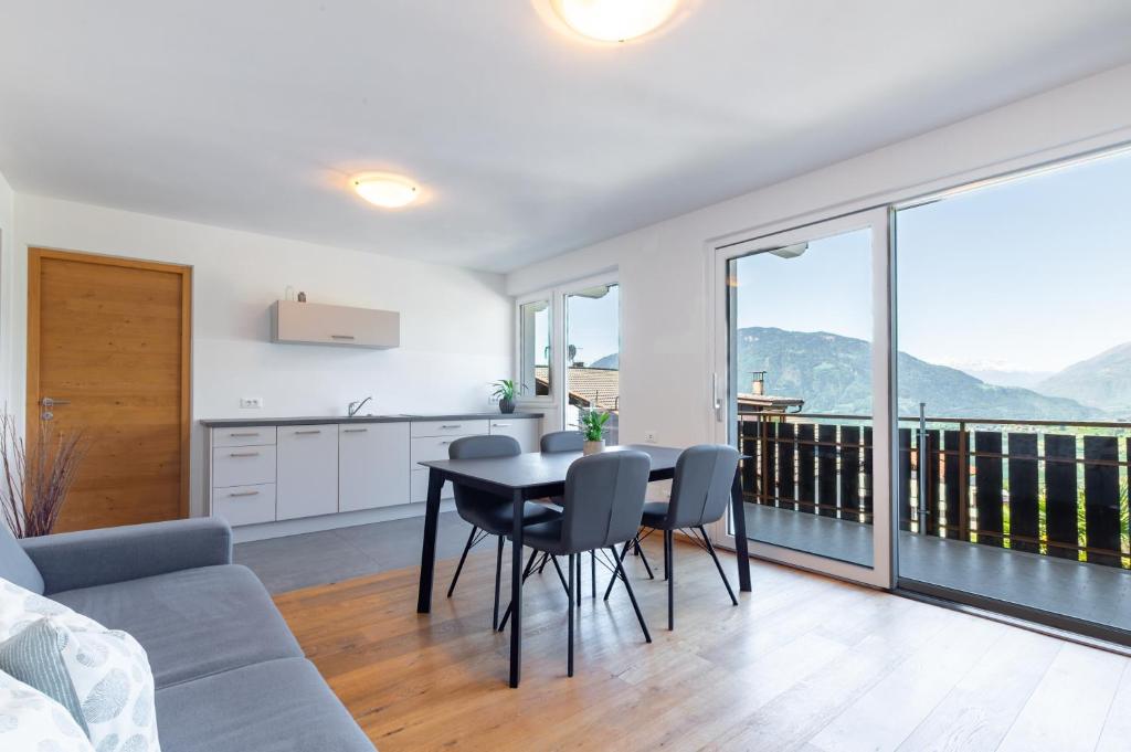 a kitchen and living room with a table and chairs at Ferienwohnungen Preiss - Schenna in Schenna