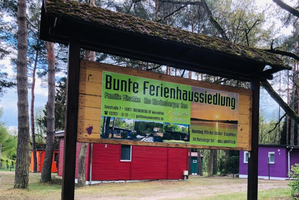 a sign in front of a red building at Bunte Ferienhaussiedlung in Rheinsberg