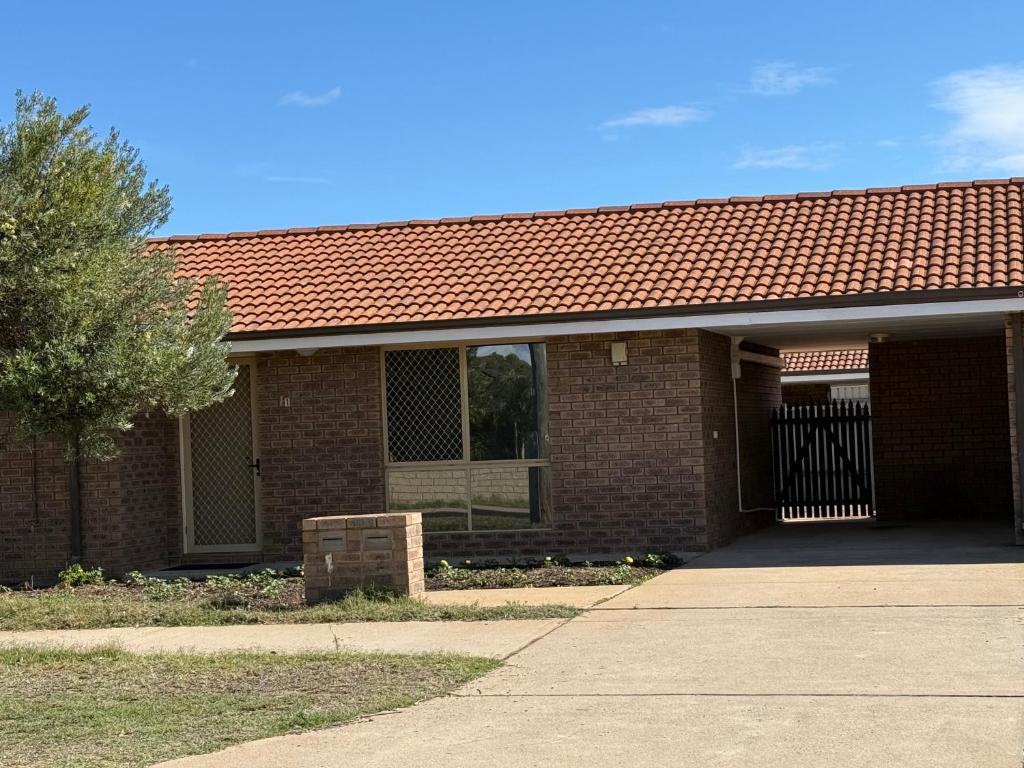 a brick building with a gate and a driveway at Good price Apartment self check-in in Geraldton