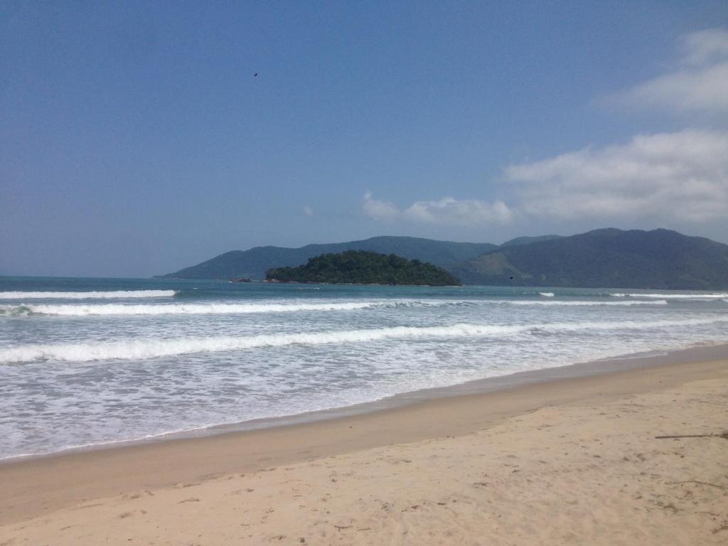 a beach with the ocean and mountains in the background at Morada Vitória in Ubatuba
