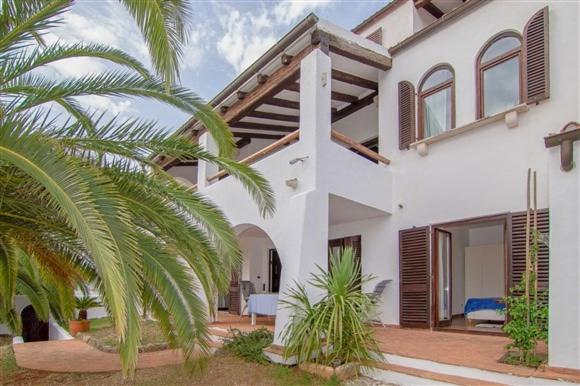a white house with a palm tree in front of it at Apartment Arte by in Pješčana Uvala