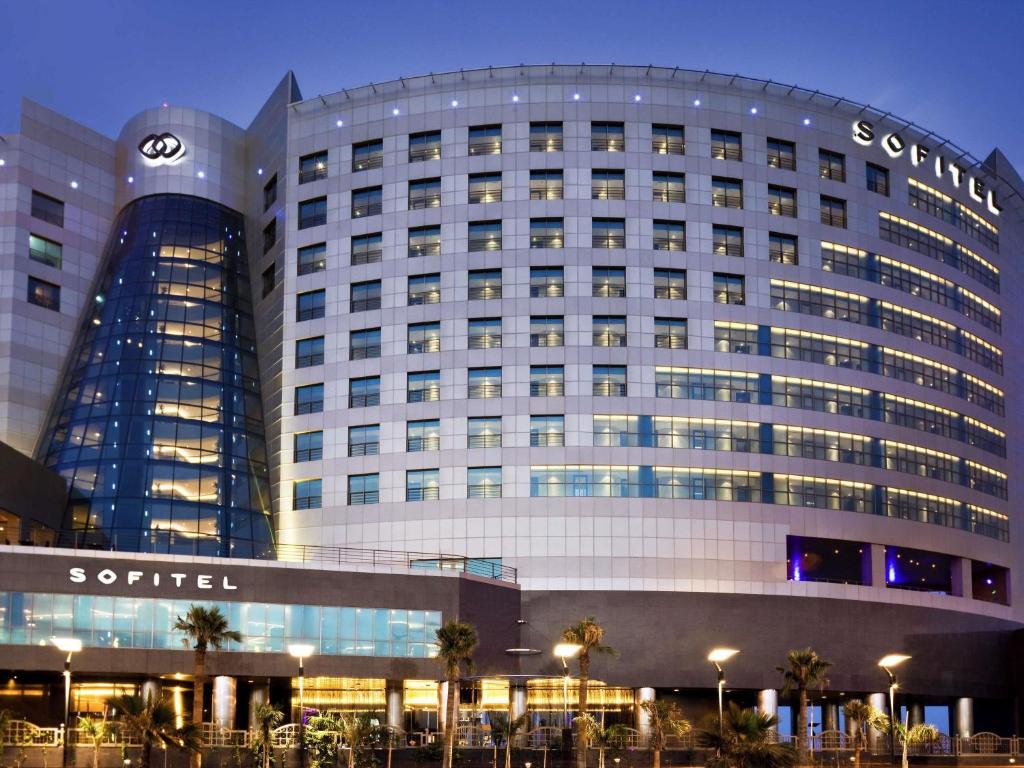 a building with a clock on the side of it at Sofitel Al Khobar The Corniche in Al Khobar