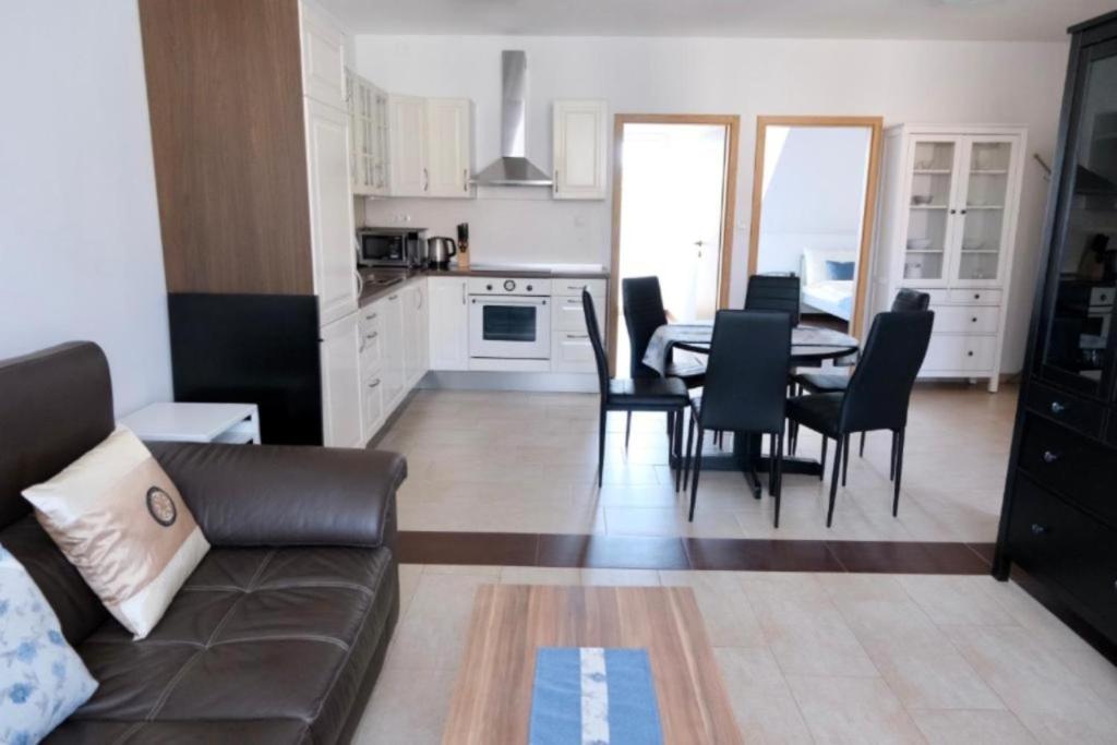 a living room with a couch and a table and chairs at Apartments MIYABI in Maribor