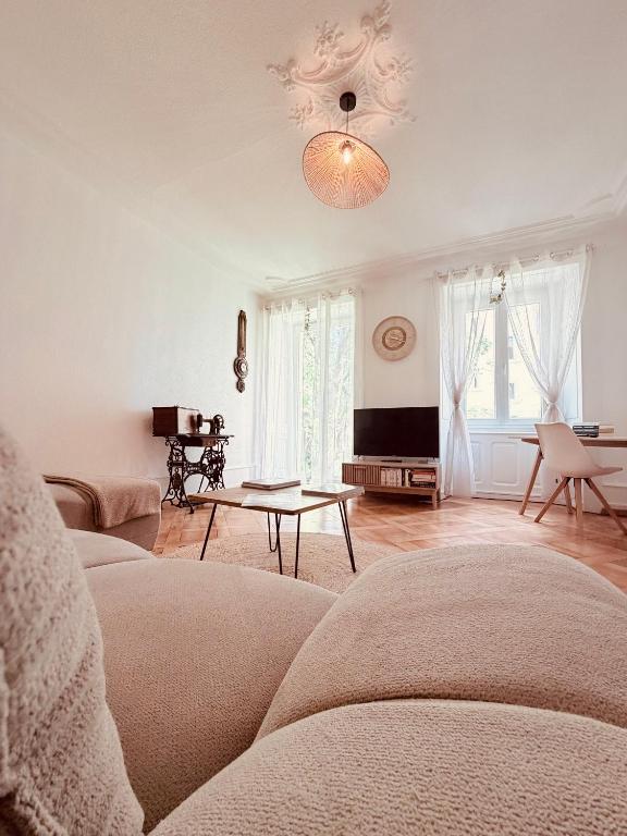 a living room with a couch and a table at Heure Cosy in La Chaux-de-Fonds