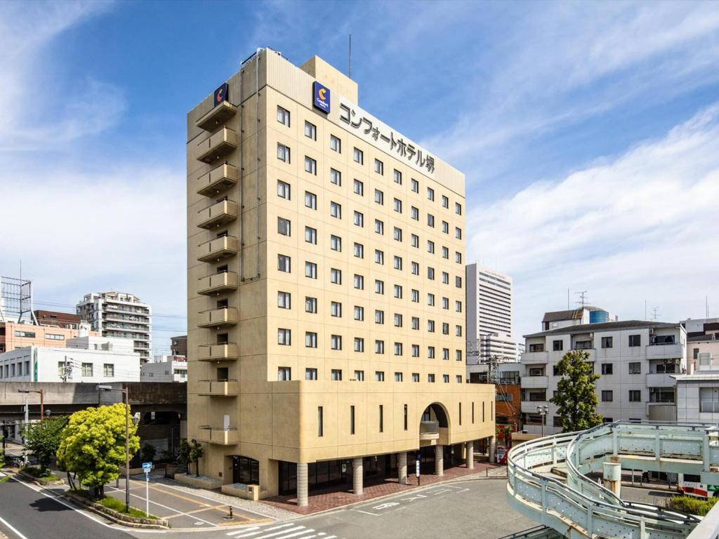 a tall white building with a sign on it at Comfort Hotel Sakai in Sakai