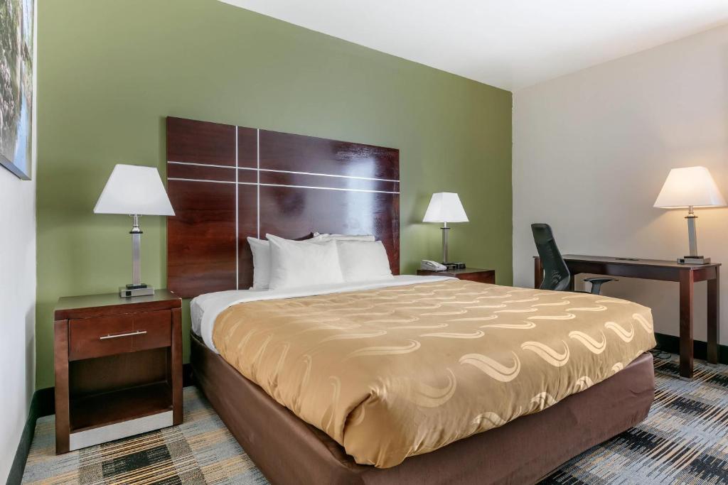 a hotel room with a large bed and two lamps at Quality Inn Cape Girardeau North in Cape Girardeau